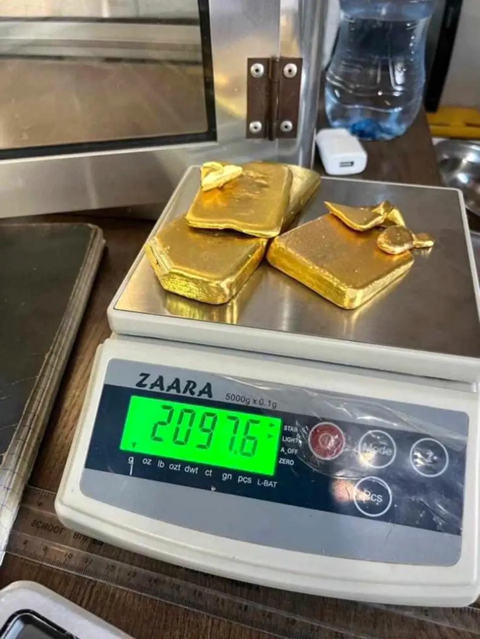 Gold bars weighed on a digital scale during sample handling