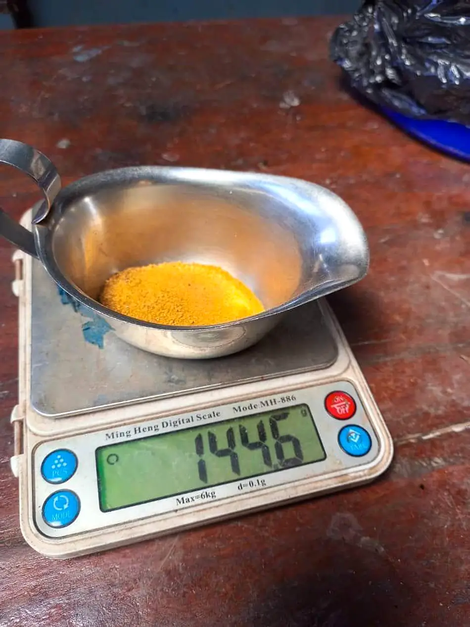 Gold sample material weighed on a digital scale before testing